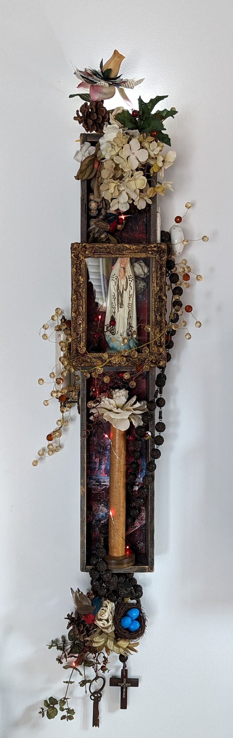This sculpture is a journey in a box: inspired by "The Miracle of Our Lady of Fatima." Elements of nature such as leaves and branches create a backdrop for a reflective, mindful walk through the woods, echoing themes of tranquility and discovery.