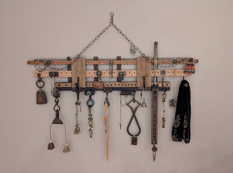 Assemblage artwork featuring rusted metal, aged jewelry, fabric, and nostalgic artifacts arranged like a collector’s wall of memories.